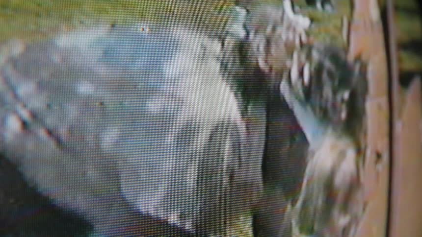 Shot of a television screen showing a video of a woman interacting with a baby outdoors