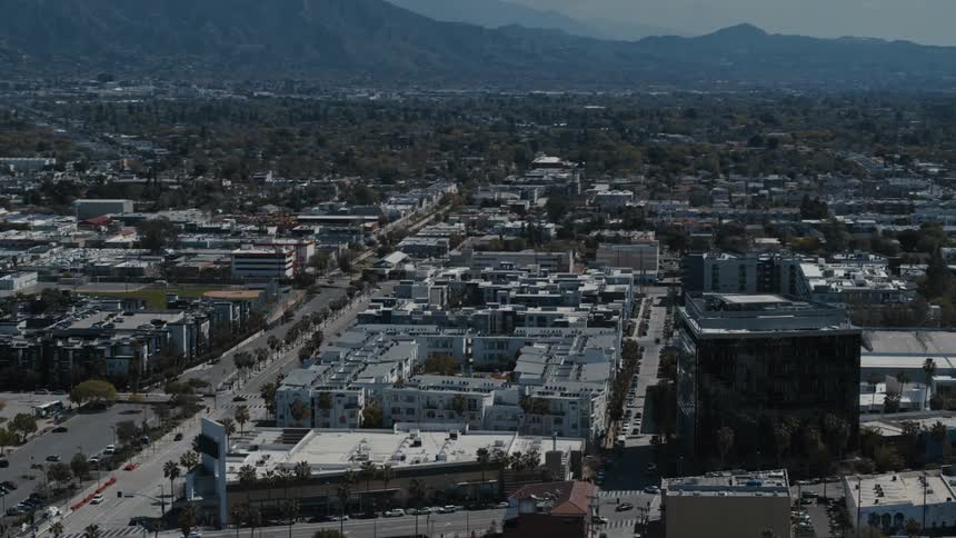 Cityscape with midrise buildings lush trees and a majestic mountain backdrop