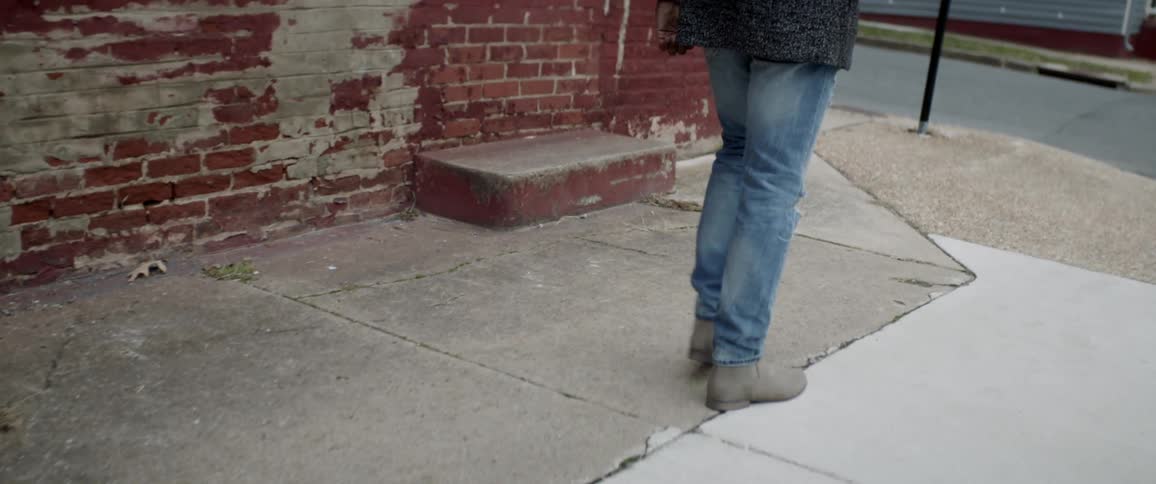 Person in jeans walks on city street