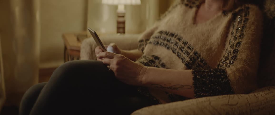 A woman is using her phone on the couch