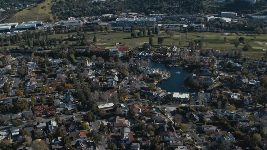 Aerial view of the Toluca Lake residential neighborhood reveals Hollywood Hills in the background