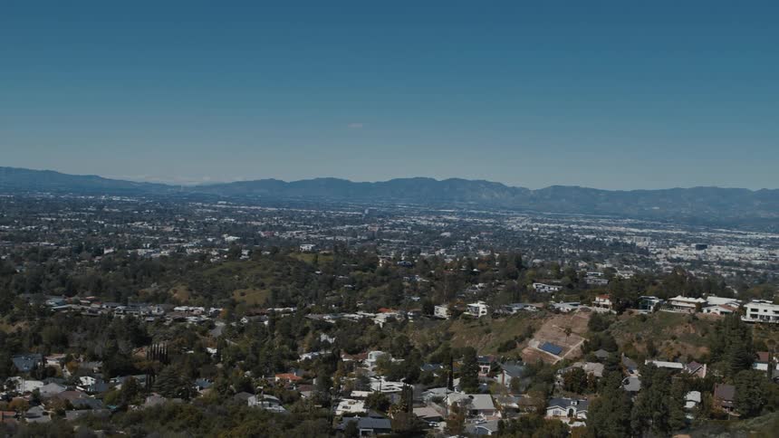 Studio City, Van Nuys, and Burbank are revealed from behind a canyon in the Hollywood Hills