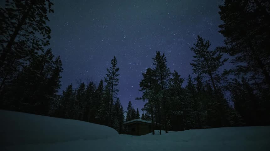 Time lapse view of a cabin in the woods during winter