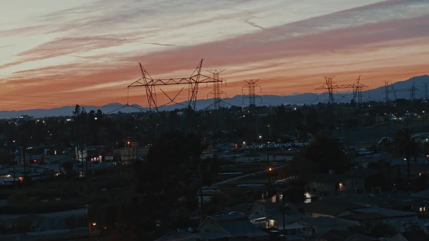 High tension powerlines towers loom over a Burbank residential neighborhood at sunset