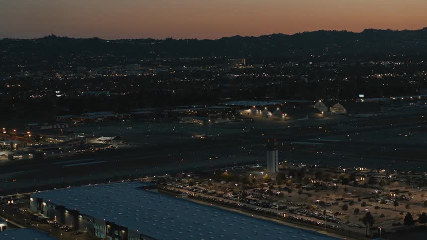 A plane arrives on the runway at Bob Hope Burbank Airport at sunset