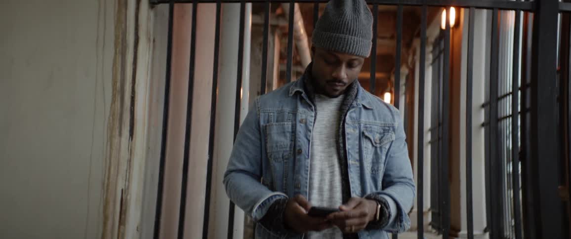 A man wearing a hat is on his phone