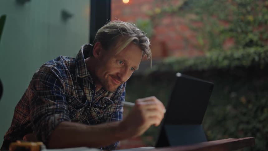 Man working on a piece of wood and then writing on a tablet device
