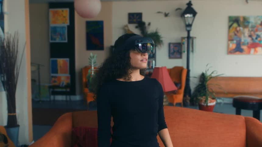 A female reaches her arm out while wearing a virtual reality headset