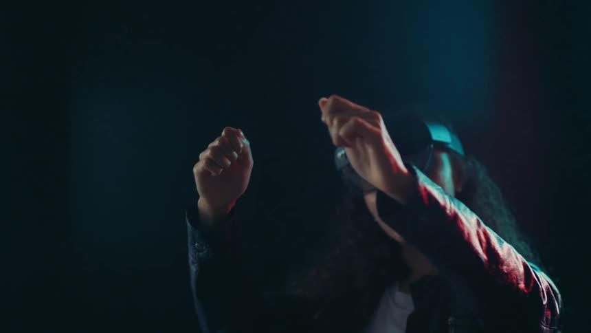 Woman wearing a virtual headset moving her hands around in the air