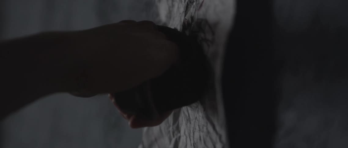 A person punches a paper with a drawing with spiked brass knuckles