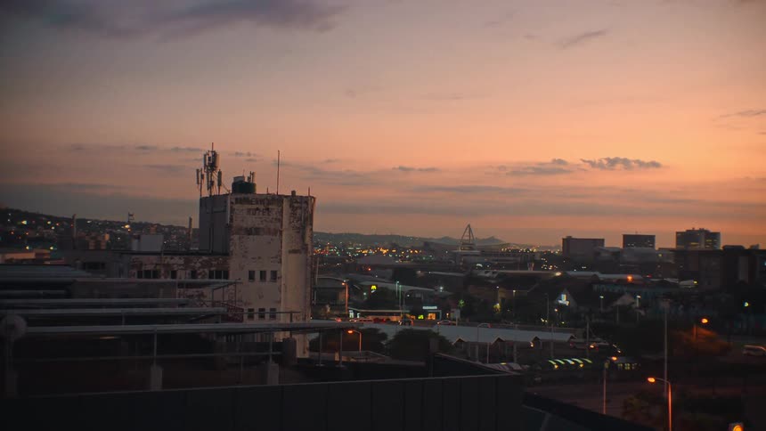 Cars are driving through a city during dusk