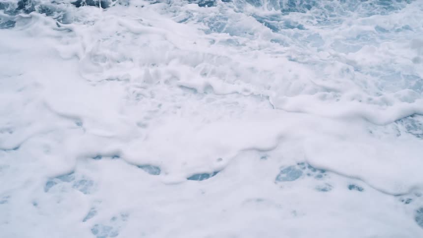 Waves foam while they churn across surface of ocean