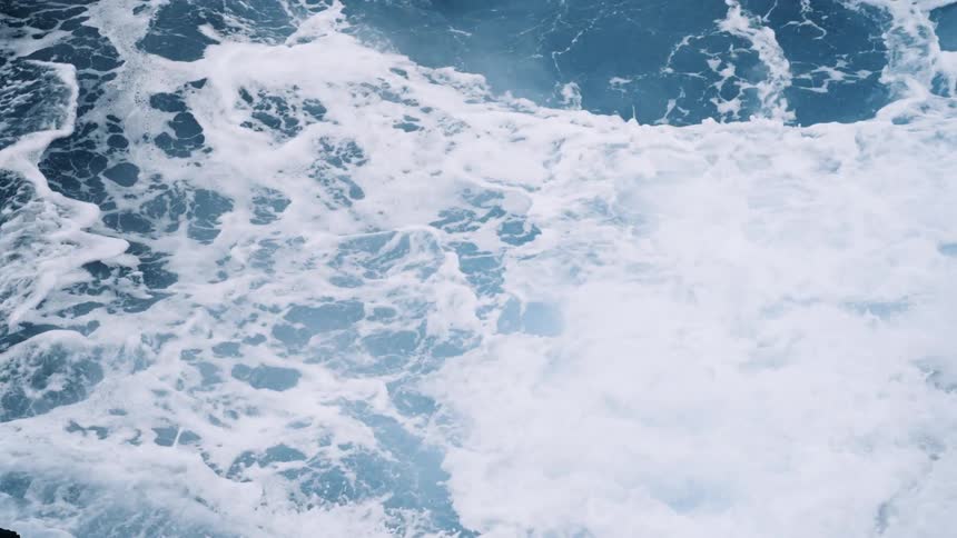 Ocean waves are crashing into each other at midday