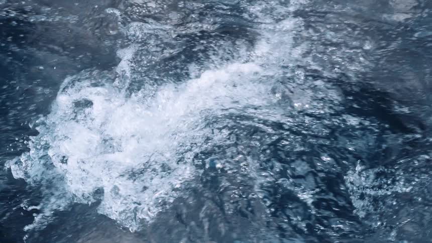 Waves foam while rolling across surface of ocean