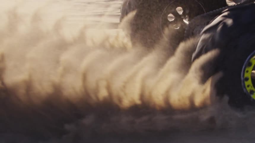 A four wheeler spins off in the sand