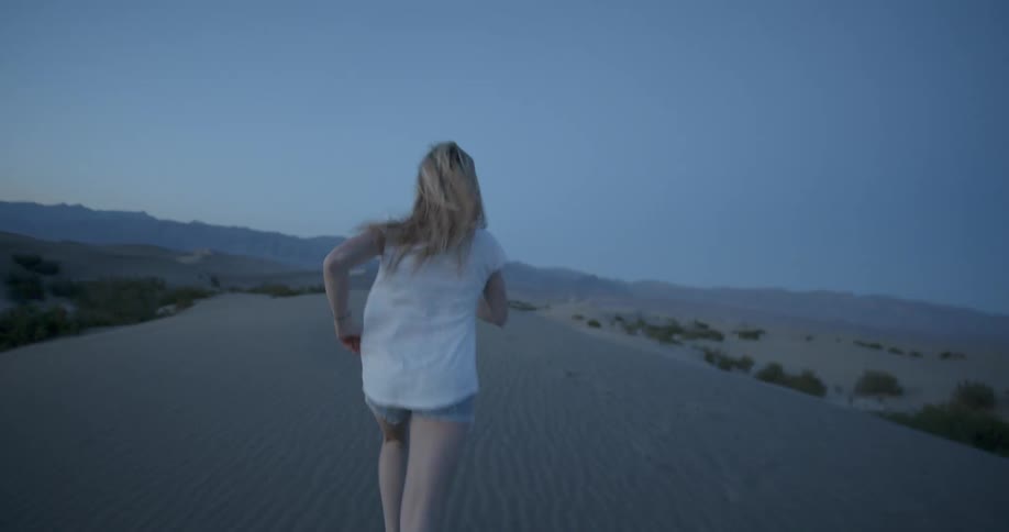 A woman runs in the desert sand