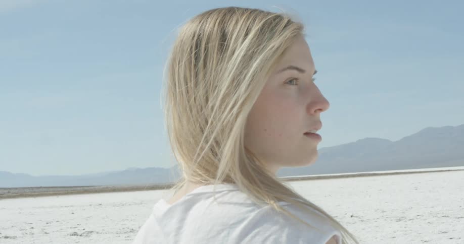 A woman looks out over a desert on a sunny day