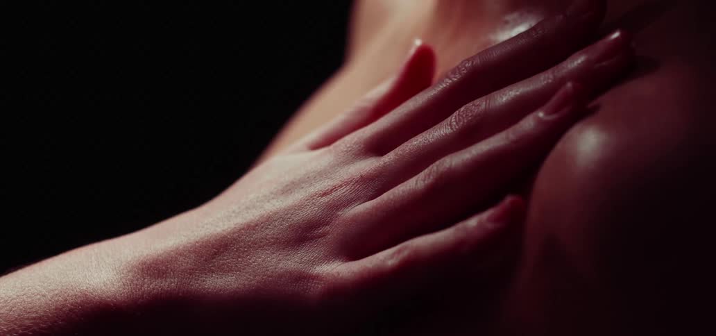 A womans hand rubbing her body with oil