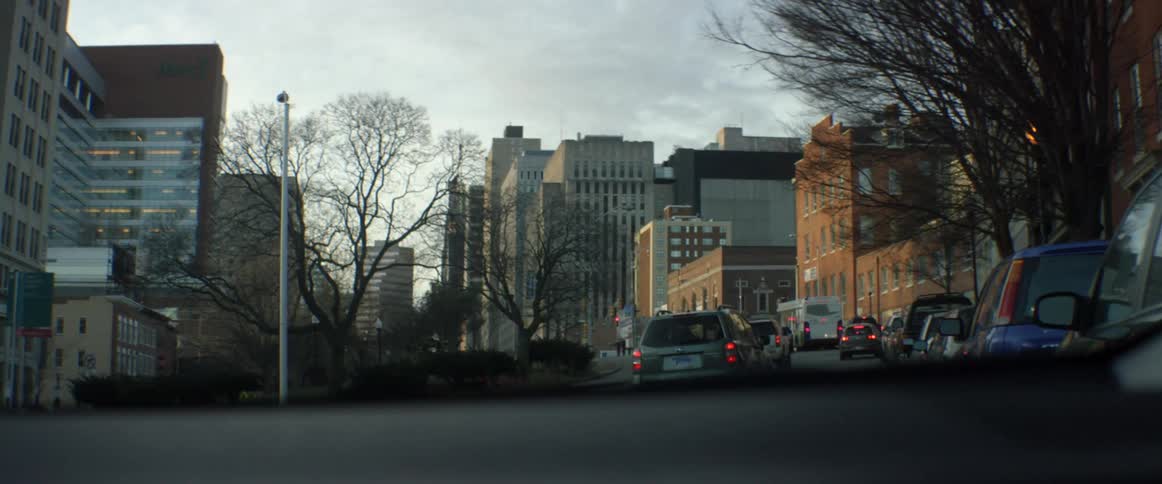 Cars drive in traffic in a city