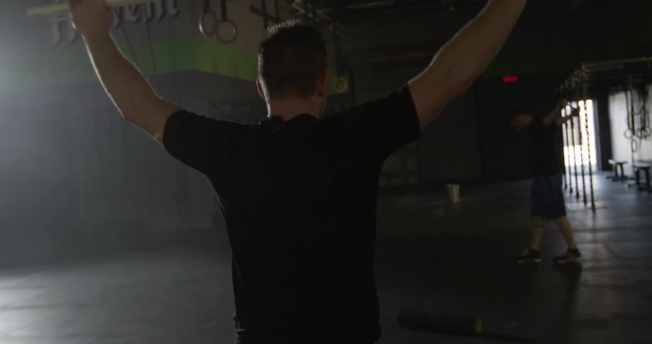 A man is lifting a bar over his head