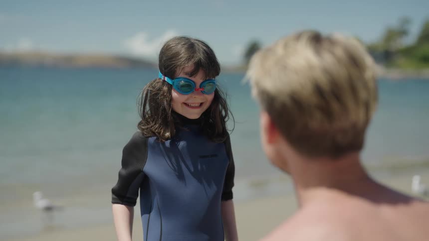A father is talking to his daughter on the beach