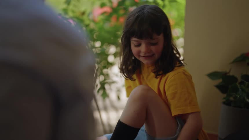 A father helping his daughter put her shoes on