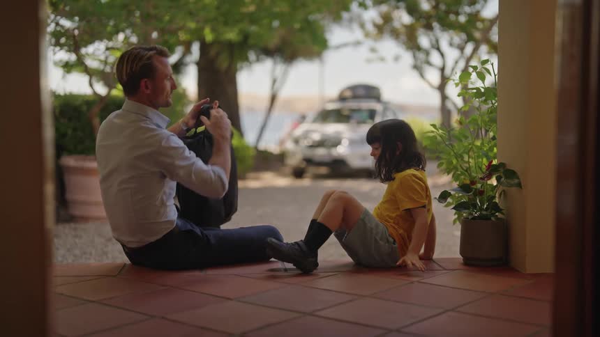 Father and daughter are sitting outdoors in the day time