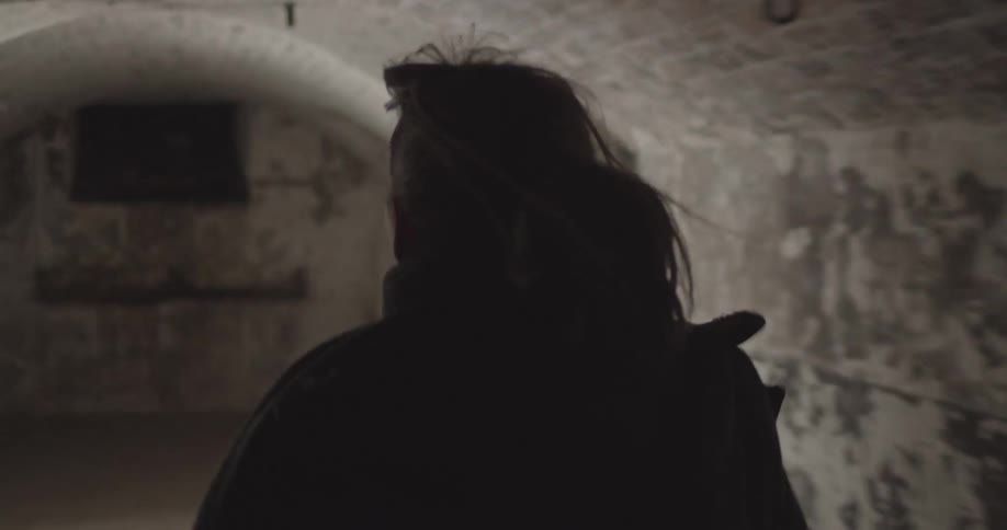 Woman runs along an abandoned tunnel searching with flashlight