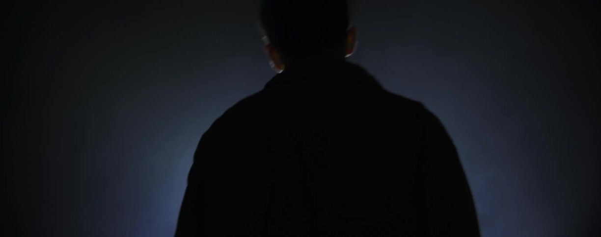 A person getting up off the floor and walking towards a light