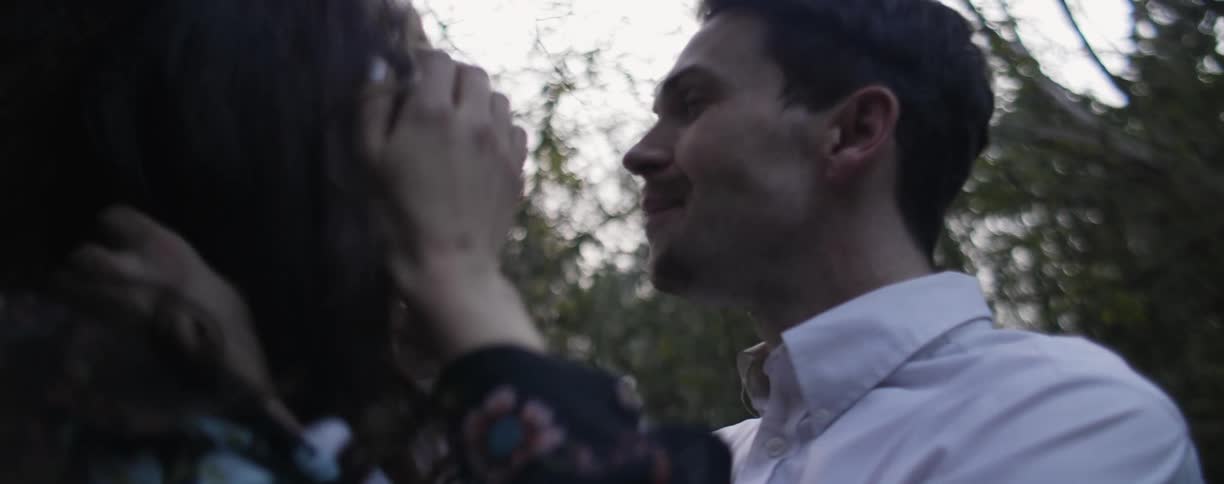 A man and woman play in a forest