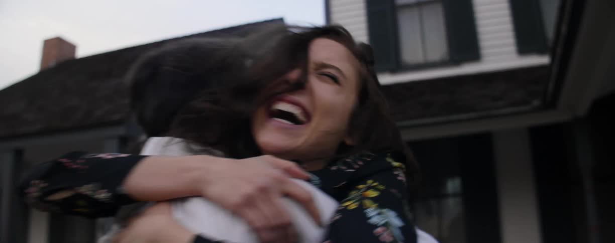 A couple run to embrace each other outside a home