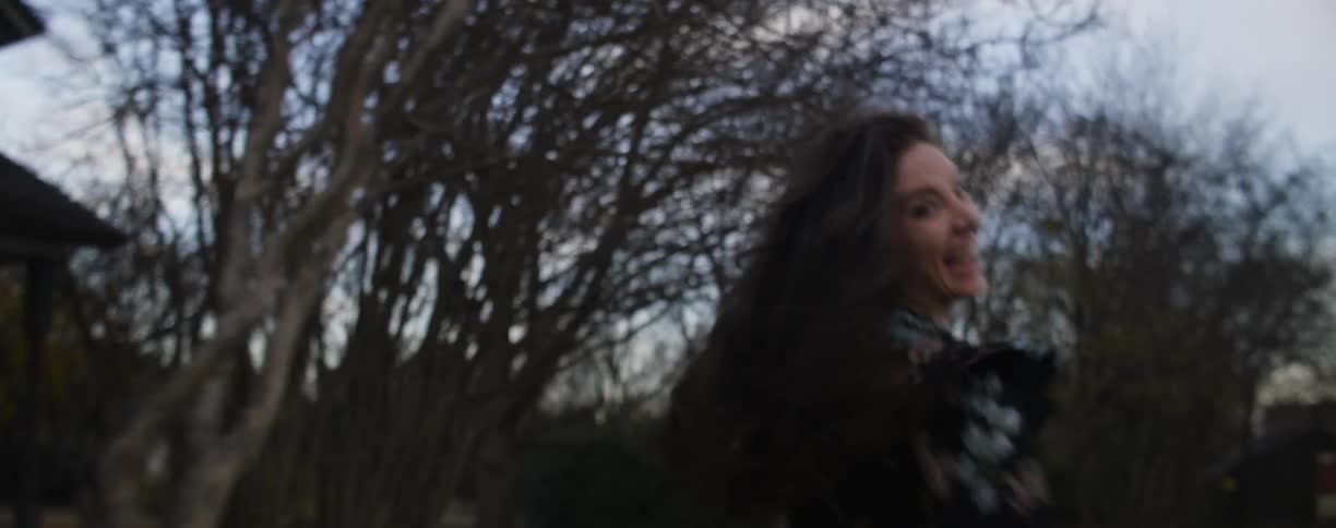 A man and woman hug, laugh and run outside