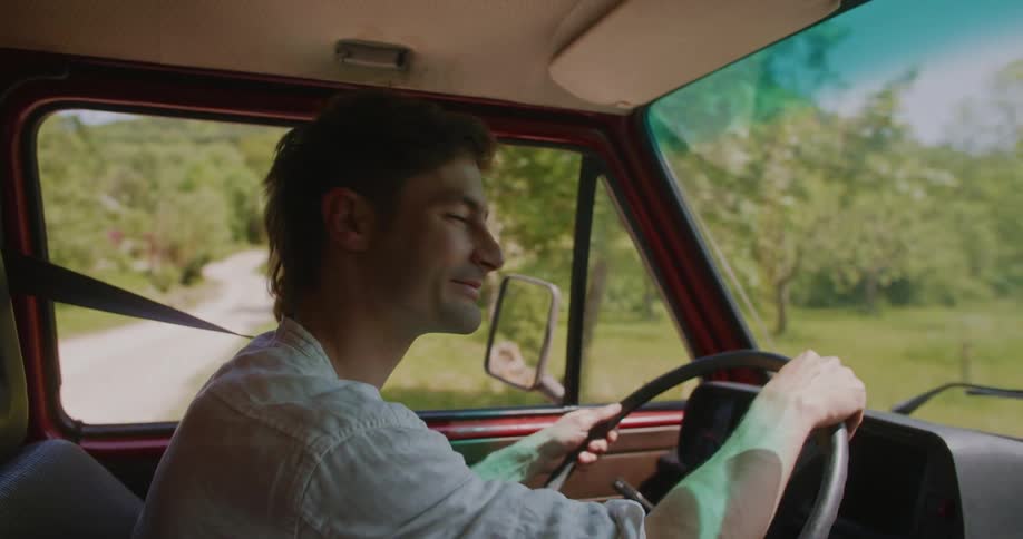 A man is driving a car during the spring time