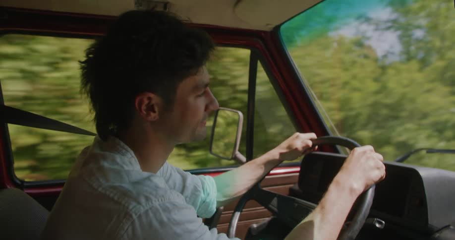 A man is driving a car during the spring time