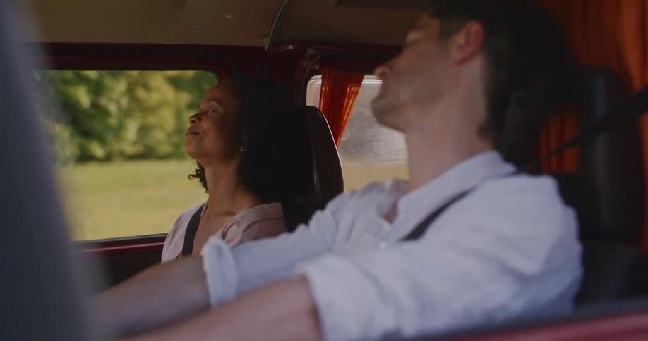 A man and woman wait in the car