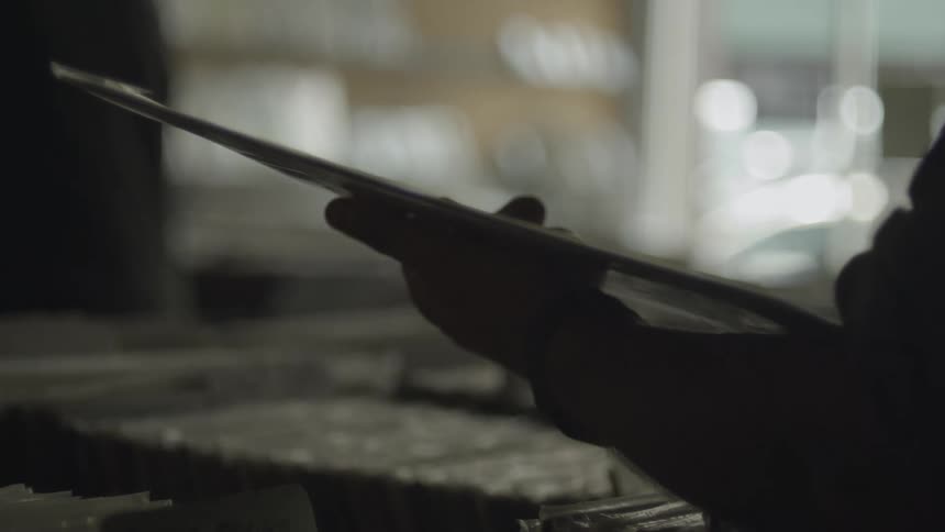 Customer stands in shop examining merchandise while traffic passes outside storefront window