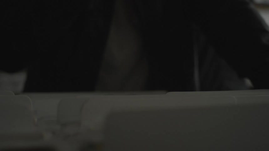 Close up of a persons hands rummaging through tab files that are stacked together
