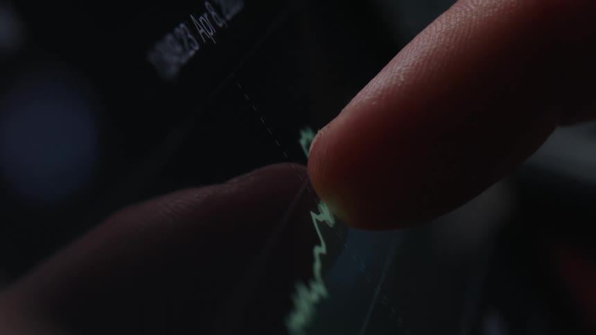 A person traces his finger across the monitor