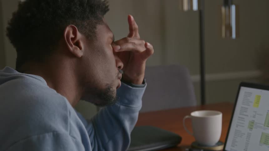 The view is of a portrait of a man that is looking at his laptop