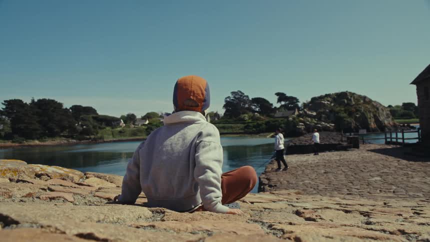 A child is watching older kids fish