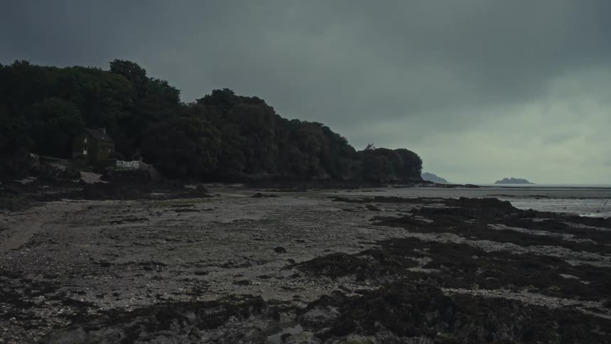 French shoreline with a house on a cloudy day