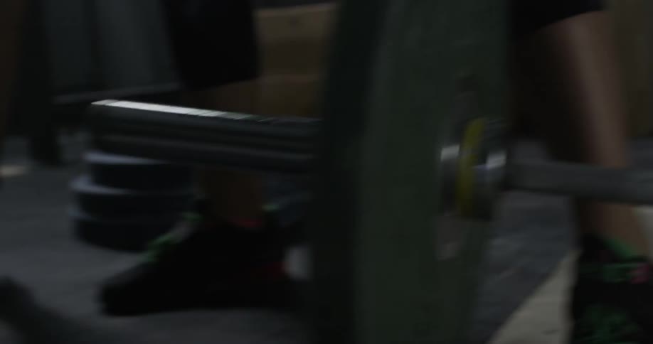 An athlete is putting a weight onto a bar