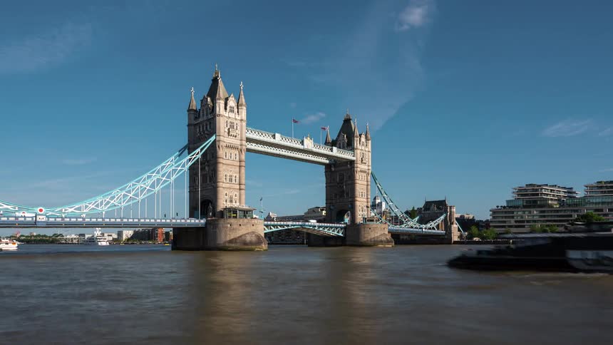 The boats and cars travel under and over the bridge