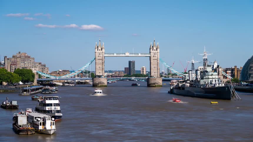 Boats and ships travel by the bridge