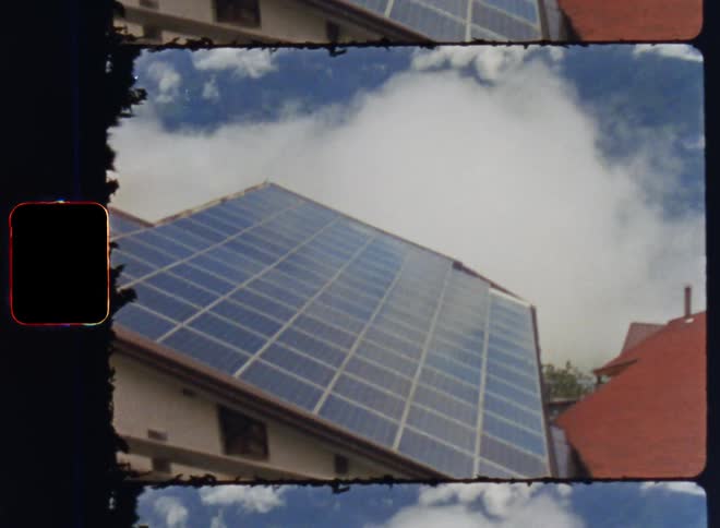 A roof with a solar panel overlooking the valley behind a dense cloud cover
