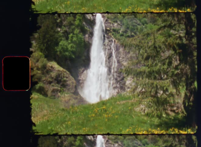 A waterfall down the side of a cliff in the wilderness during the day