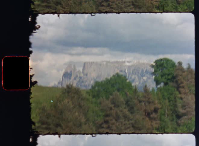 Film footage of a mountain during a cloudy day