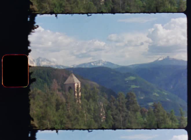 A mountain with lot of green grasses and a small house built on the mountain with a clear cloud