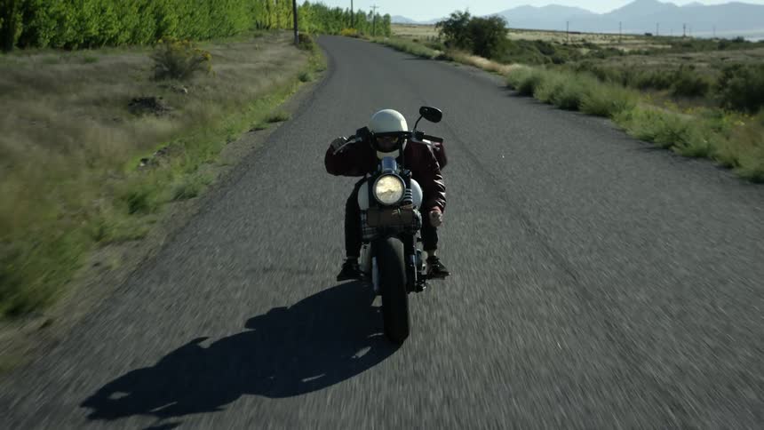 Man balances on a motorcycle and jumps to a seated position