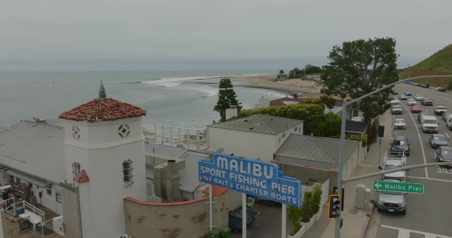Aerial shot of the malibu sport fishing pier with the coast to one side and traffic on the road to the other